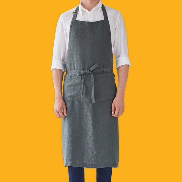 Man in white shirt wearing the Forest Green washed linen chef apron from Linen Tales.