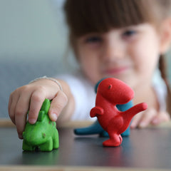 Child playing with Plan Toys Dino Set made from wood. 